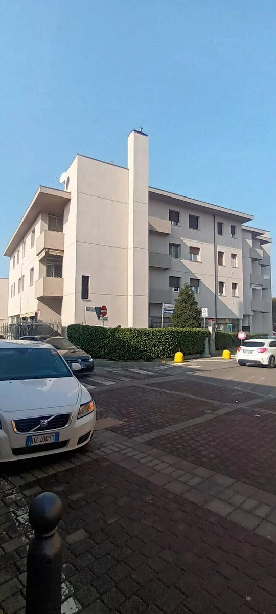 Angolo di palazzina con facciata rifinita e serramenti nuovi.
