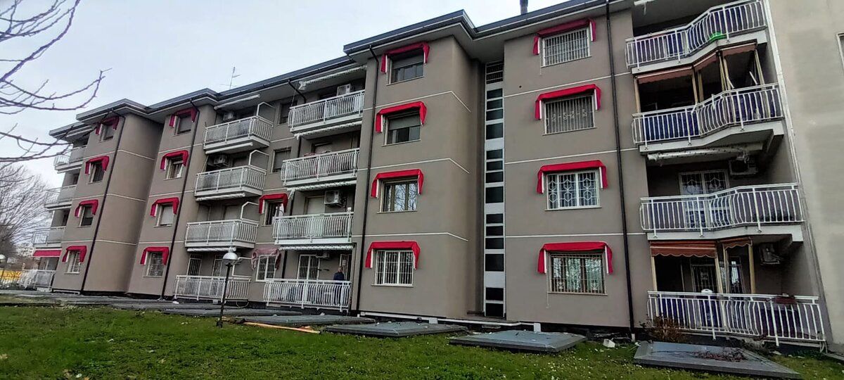 Condominio con facciata rifatta e serramenti con contorni color mattone, a lavori conclusi.